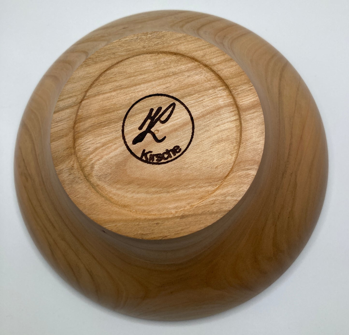 Gedrechselte Schüssel aus Kirschenholz, zeigt die Unterseite der Schüssel mit Gravur