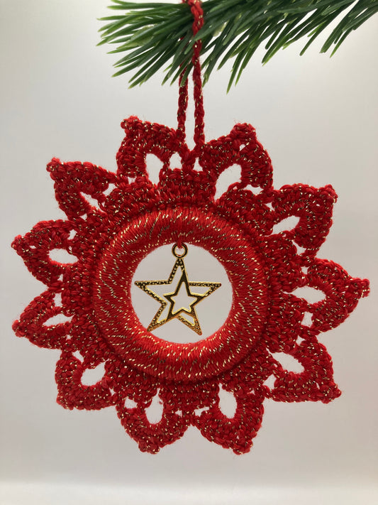 Roter Weihnachtsstern mit Stern an grünem Zweig hängend