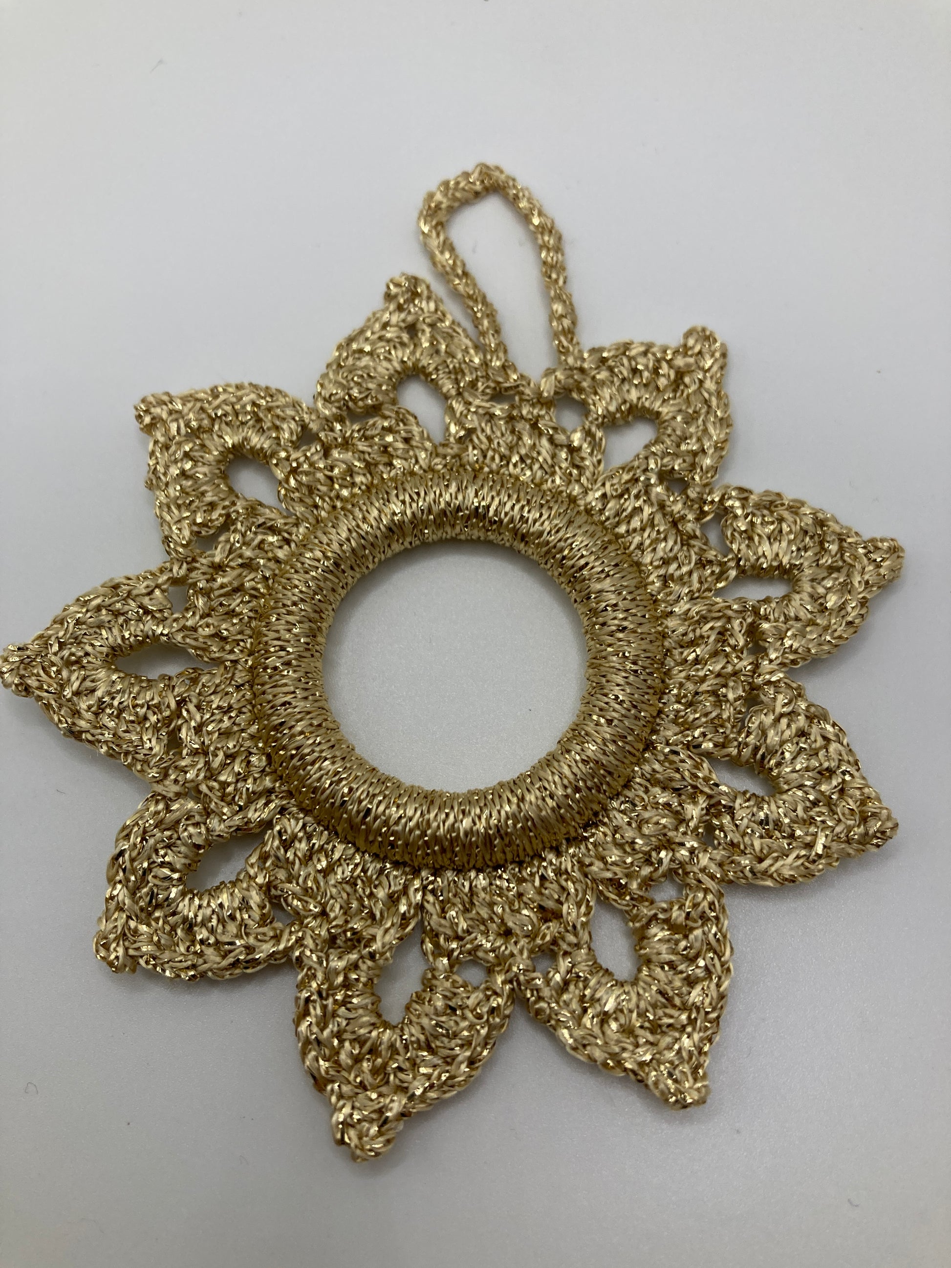 Goldener Häkelstern liegend - zeigt die Vorderseite