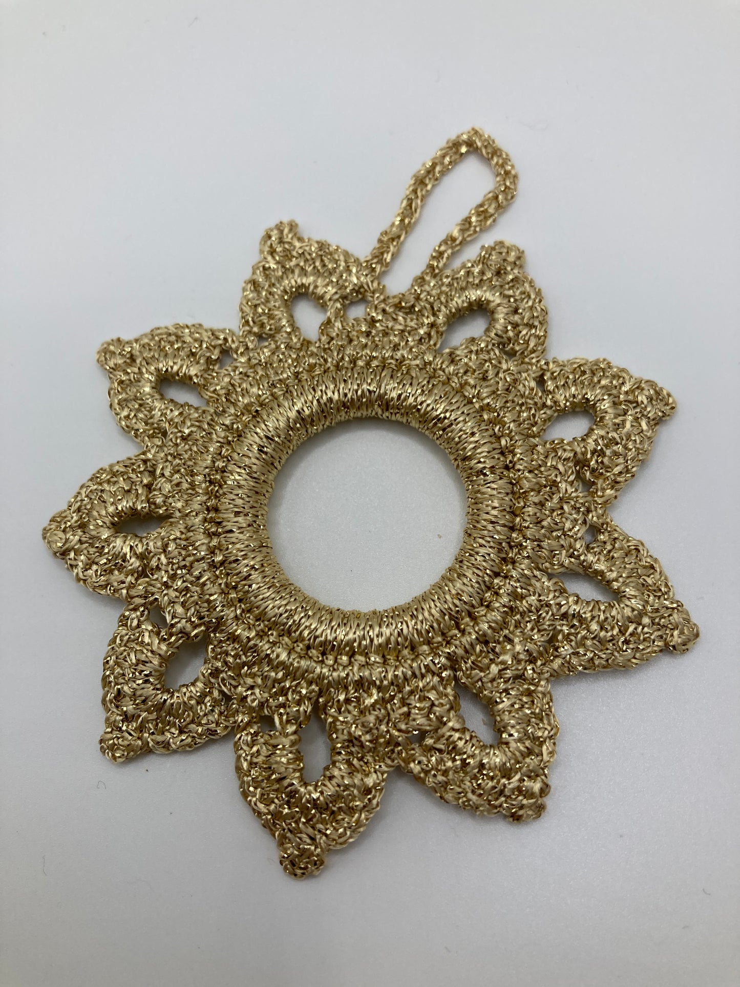 Goldener Häkelstern liegend - zeigt die Rückseite